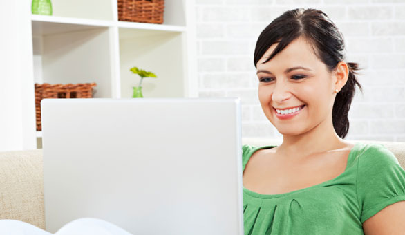 Woman Working on a Couch with a Laptop